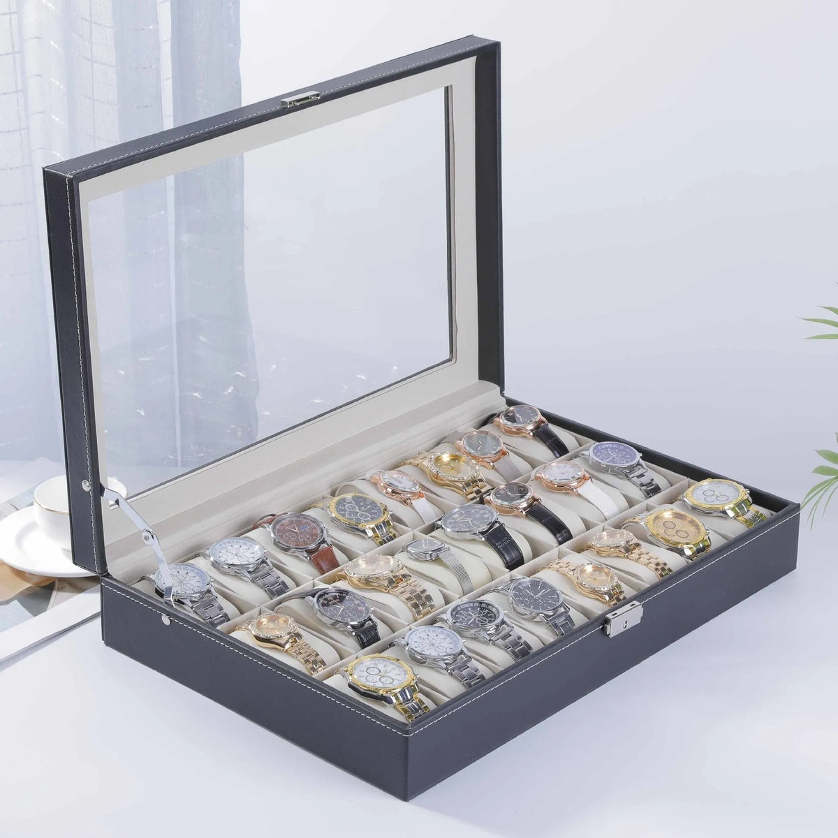 Grey leather watch storage box with clear dustproof lid showing watch cushions inside