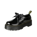 Black women's thick-soled leather lace-up shoes with a cross strap design on a white background.