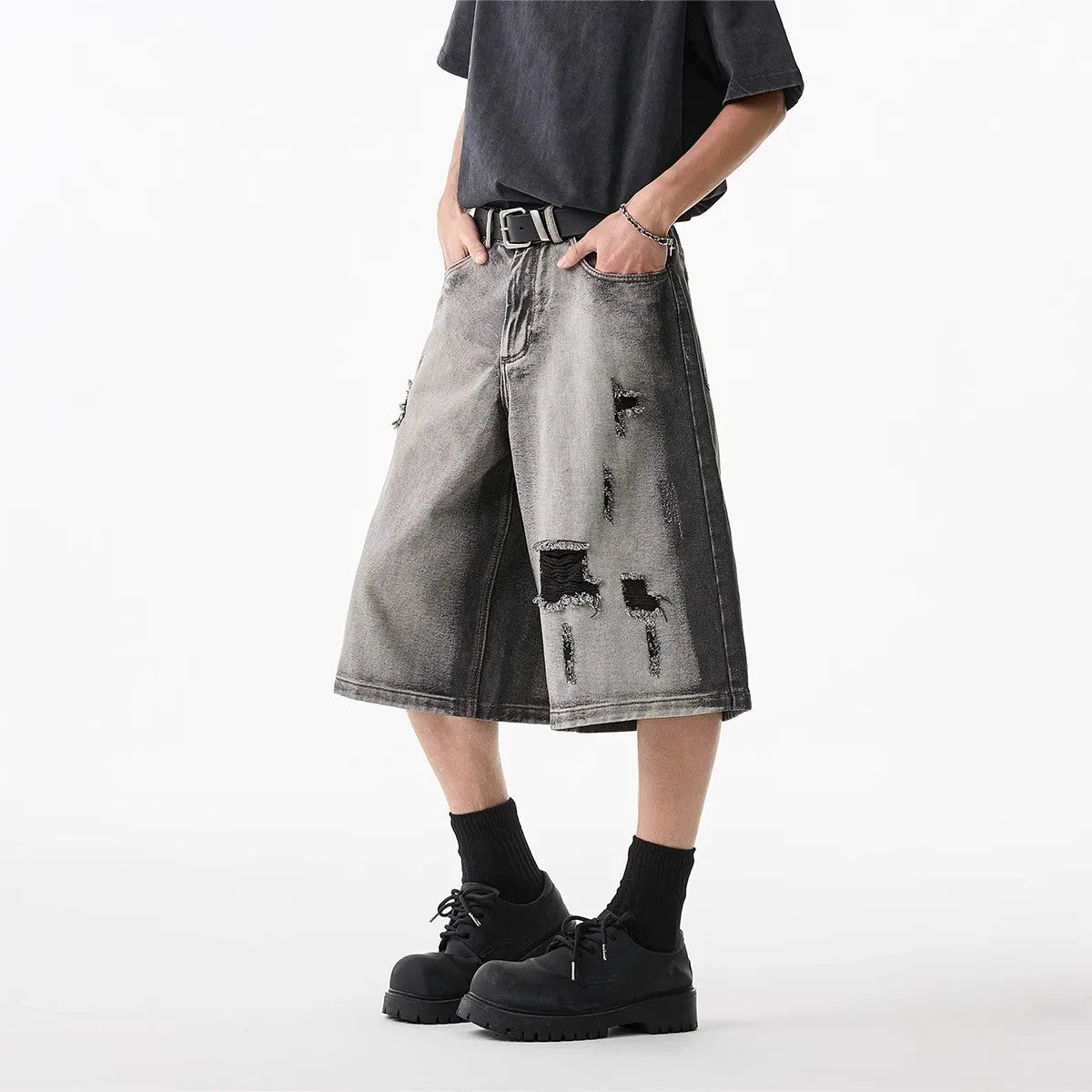 Women's loose-fit washed grey denim shorts with distressed hole details, cropped length.