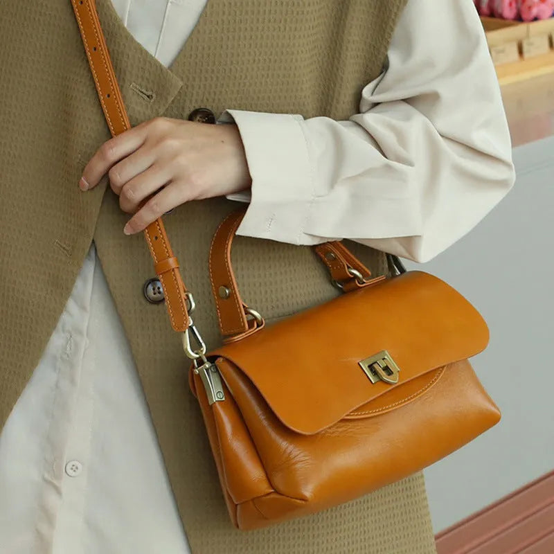 A dark brown women's leather saddle handbag with visible stitching and an open front pocket.