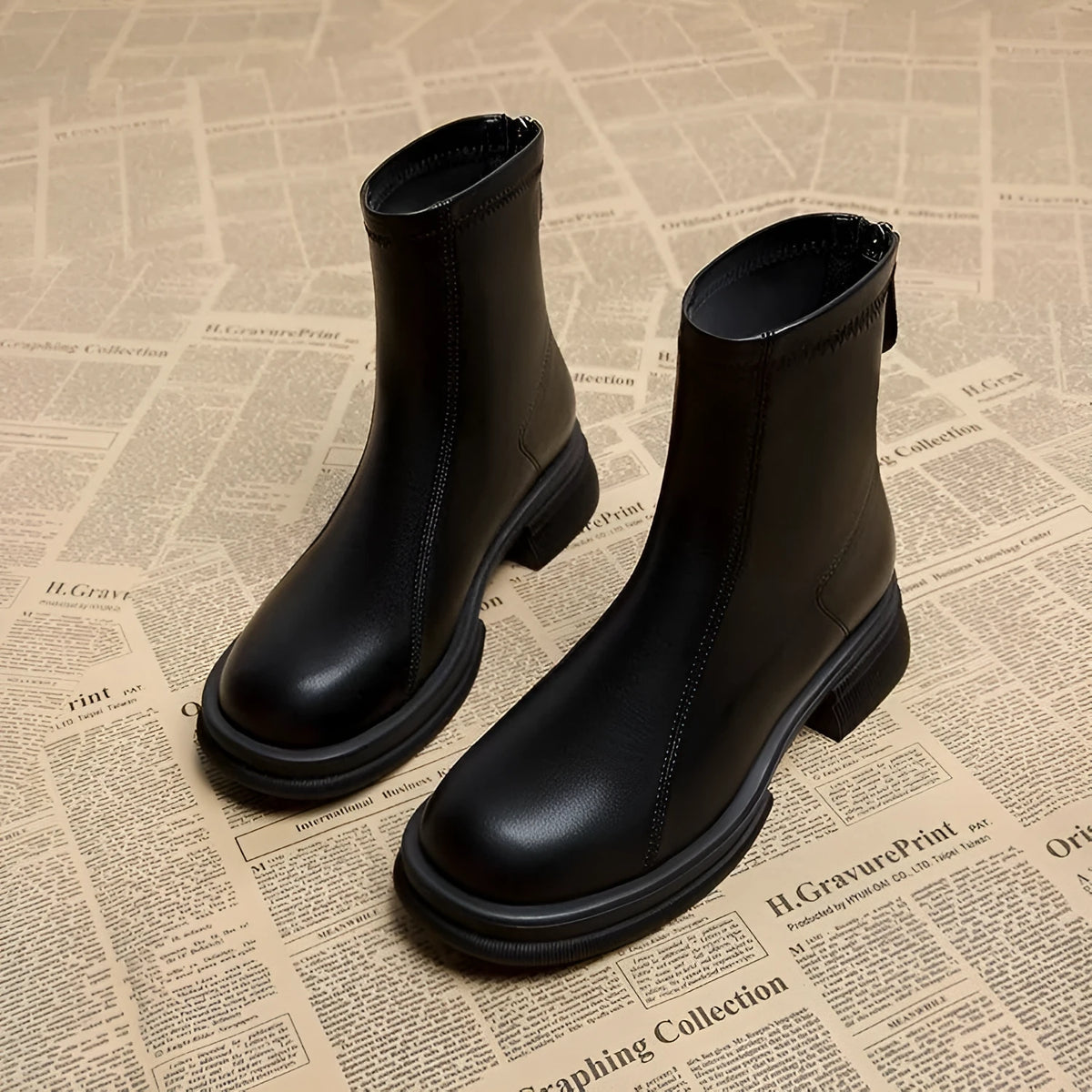 Women's black ankle boots with a thick flat heel, round toe, and back zip fastening.