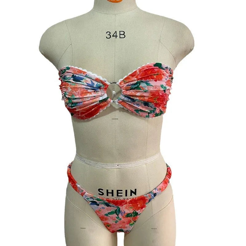 Women's floral print tube top bikini set with lace trim on a blue background.