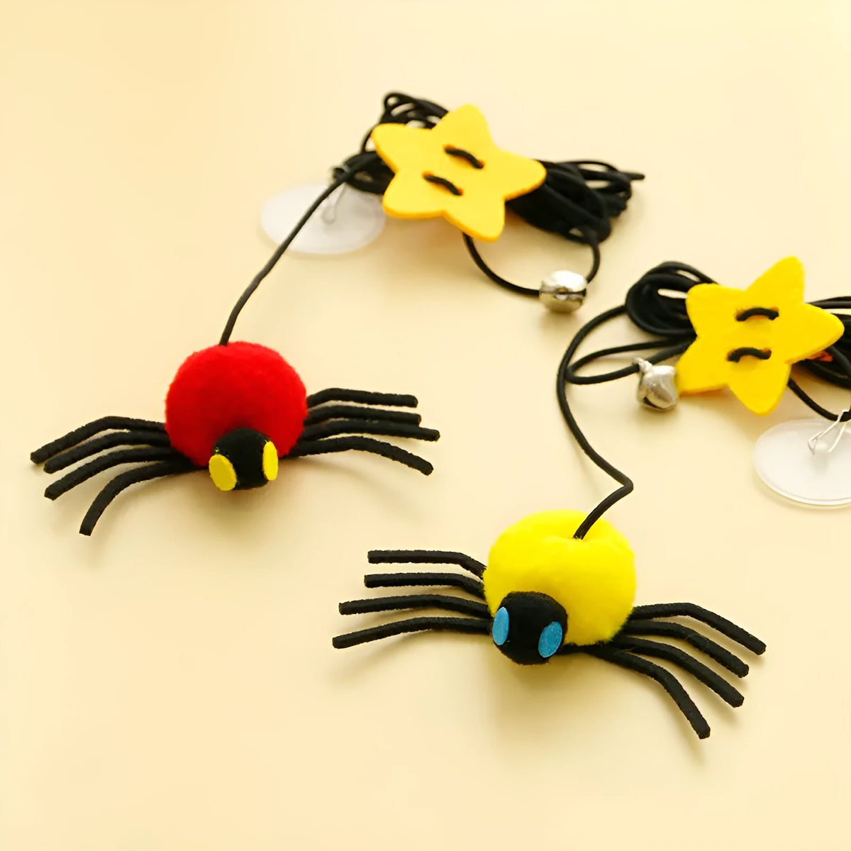 Red and yellow cat hanging door toy with elastic rope, feathers, a bell, and a spider attachment.